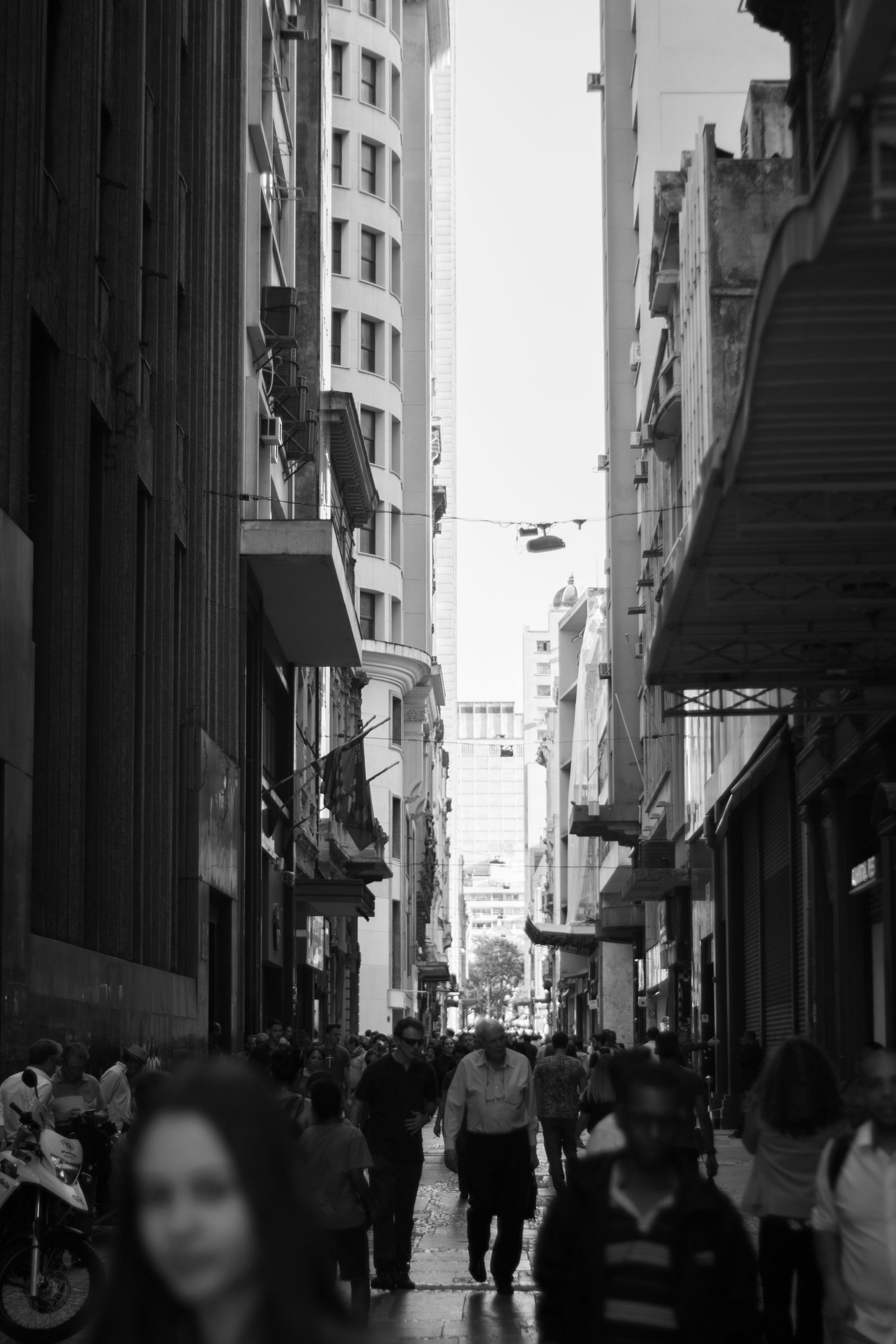 Calle urbana llena de gente caminando entre edificios